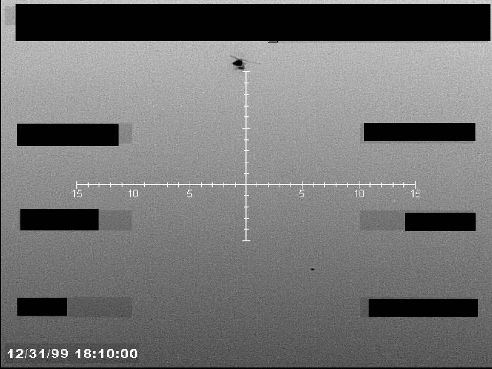 Redacted sensor image with a targeting reticle and a visible object.