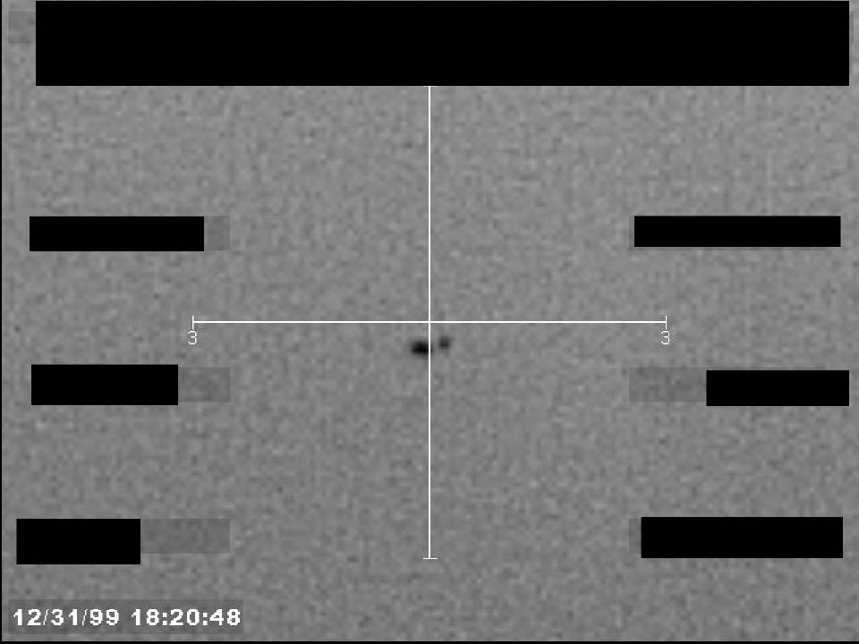 Redacted sensor image with a crosshair targeting a visible object.