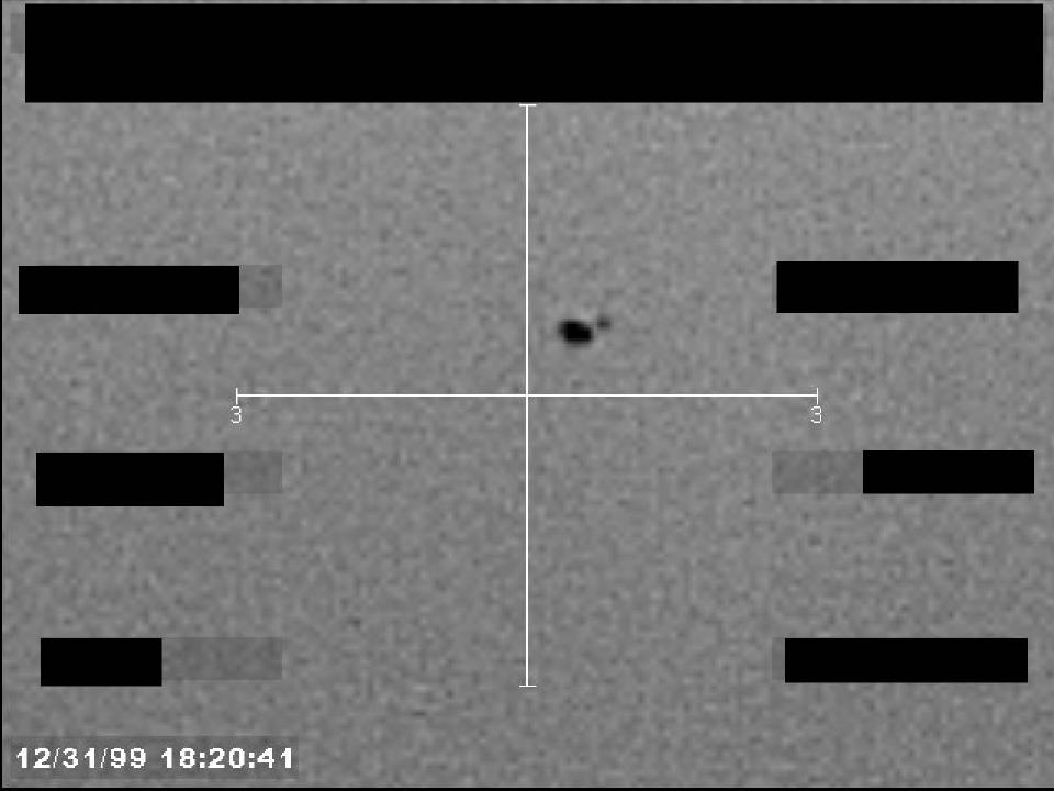 Redacted sensor image with a crosshair targeting a visible object.