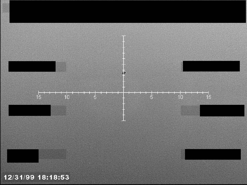 Redacted sensor image with a targeting reticle centered on an object.