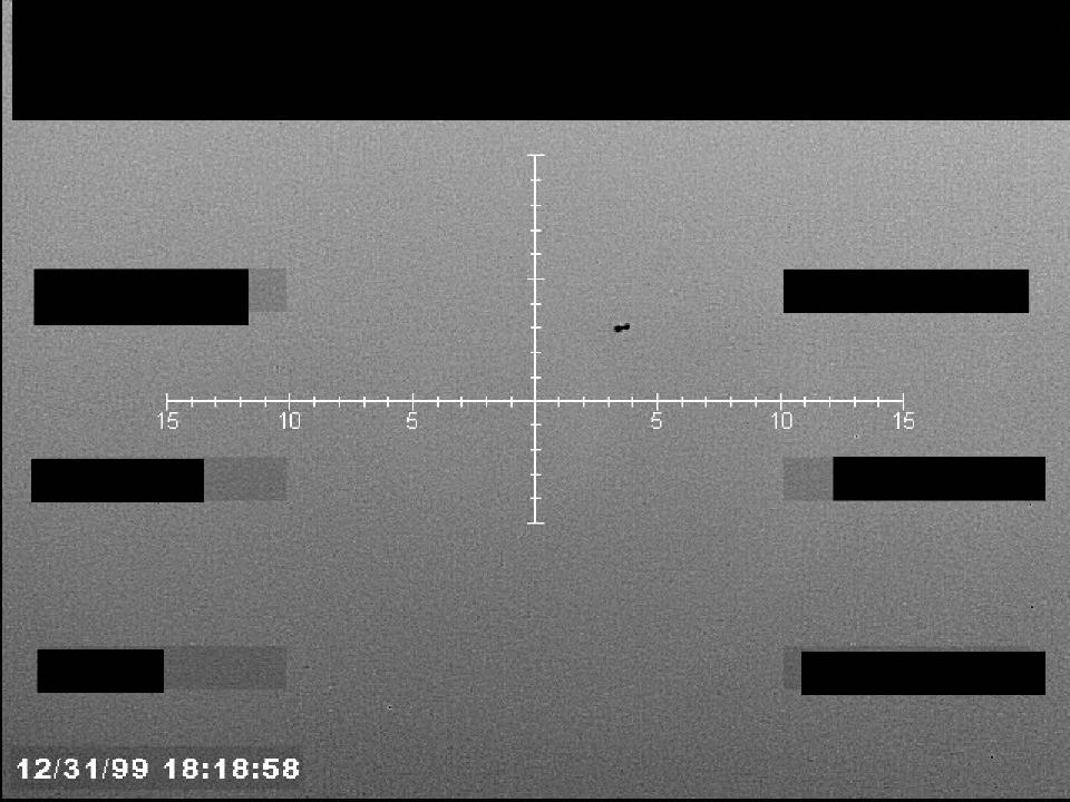 Redacted sensor image with a targeting reticle centered on an object.