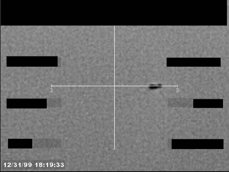Redacted sensor image with a targeting reticle centered on an object.