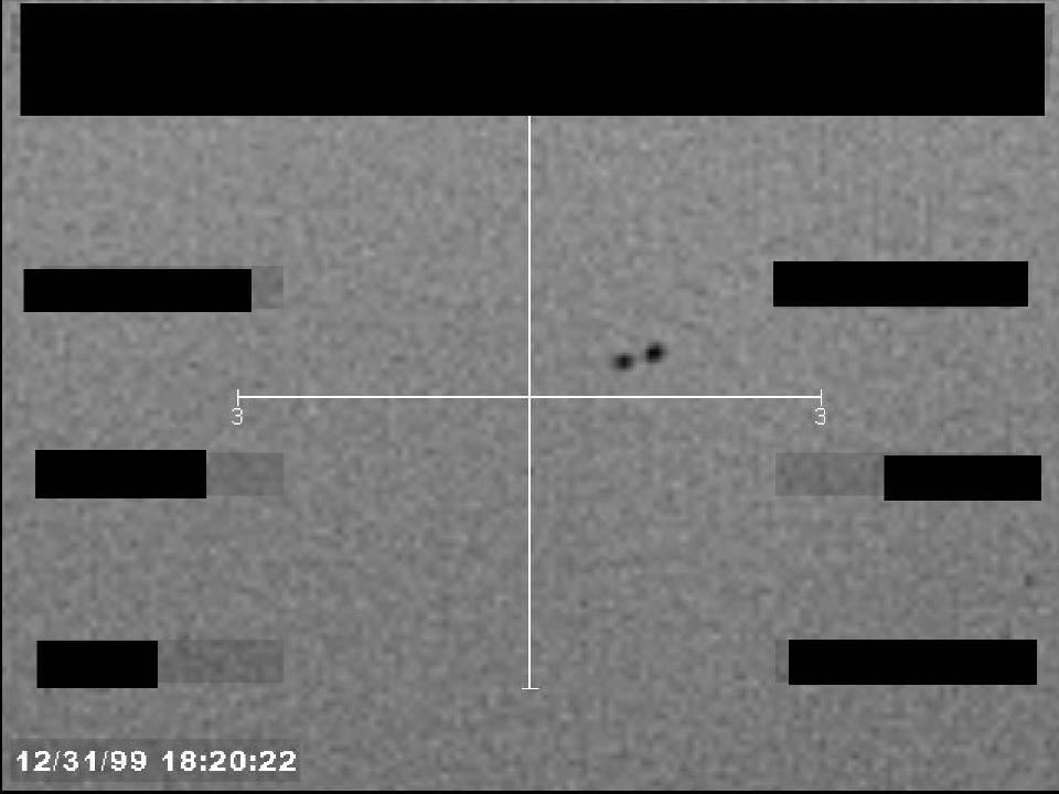 Redacted sensor image with a crosshair targeting a visible object.