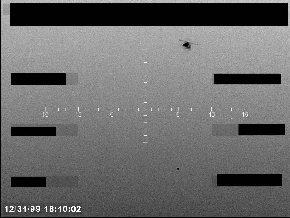 Redacted sensor image with a targeting reticle and a visible object.