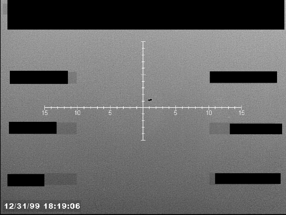 Redacted sensor image with a targeting reticle centered on an object.