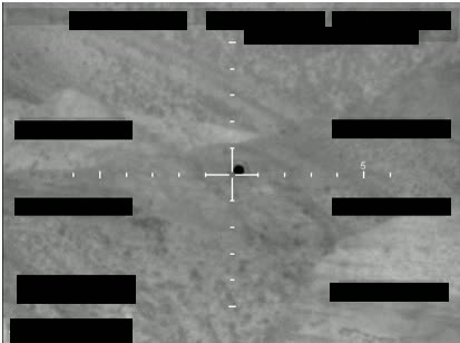 Redacted sensor image with a crosshair targeting an object.